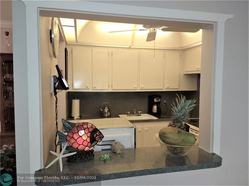 287 Markham M, Unit 287 Deerfield Beach, FL 33442 - Photo 22 of 64 a kitchen with a sink and a stove next to a window