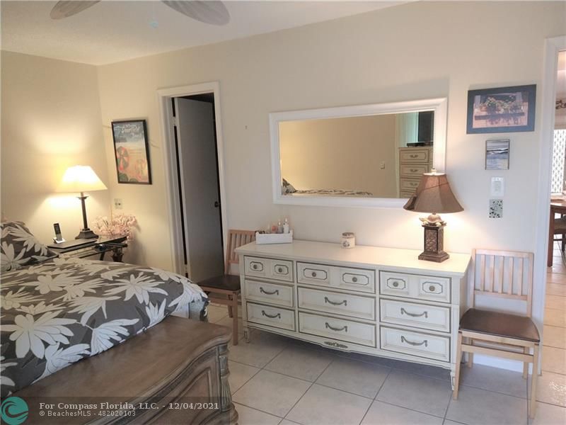 287 Markham M, Unit 287 Deerfield Beach, FL 33442 - Photo 39 of 64 a bedroom with a bed and a dresser in it