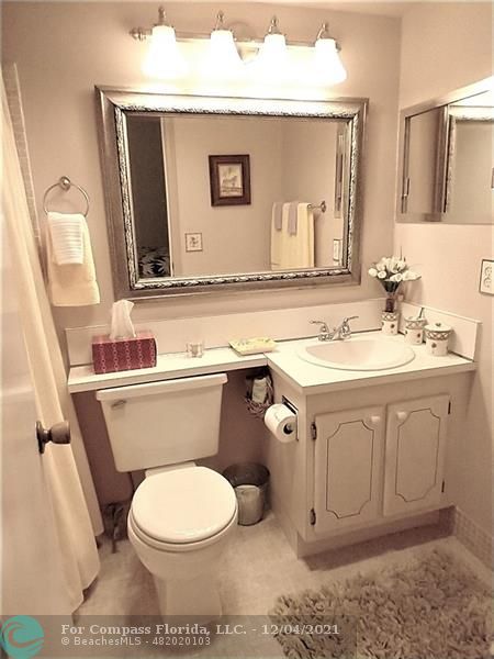 287 Markham M, Unit 287 Deerfield Beach, FL 33442 - Photo 47 of 64 a bathroom with a toilet a sink a mirror and vanity