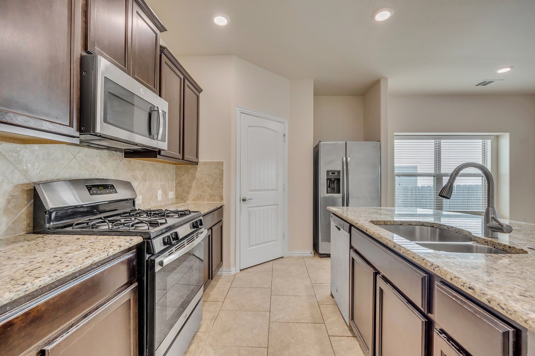 7212 Vail Ridge Street Austin, TX 78744 - Photo 3 of 26 Culinary creations come to life in this kitchen, boasting stainless steel appliances and ample counter space.