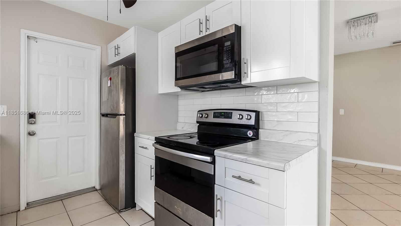 6528 Southwest 26th Street Miramar, FL 33023 - Photo 11 of 29 a kitchen with a stove and a microwave