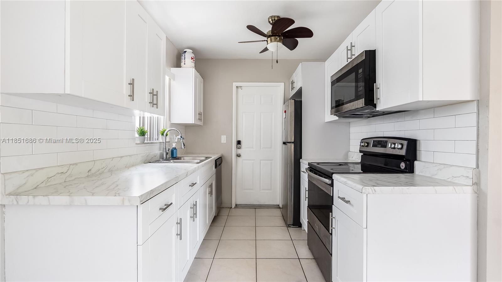 6528 Southwest 26th Street Miramar, FL 33023 - Photo 12 of 29 a kitchen with a sink stove and microwave