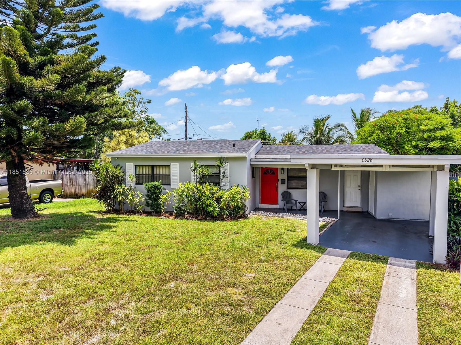 6528 Southwest 26th Street Miramar, FL 33023 - Photo 2 of 29 a front view of a house with garden