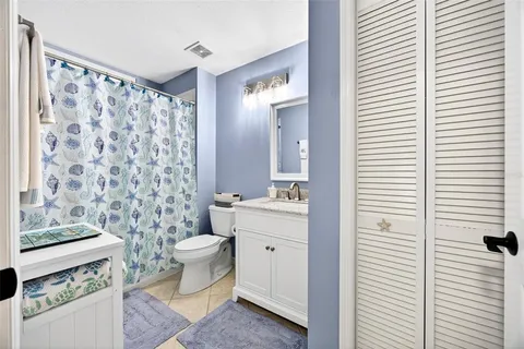 a bathroom with a granite countertop sink a toilet and a mirror