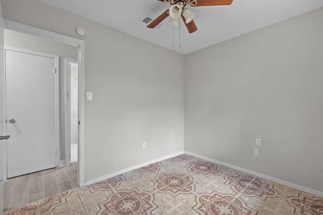 a view of a big room with wooden floor and windows in a room