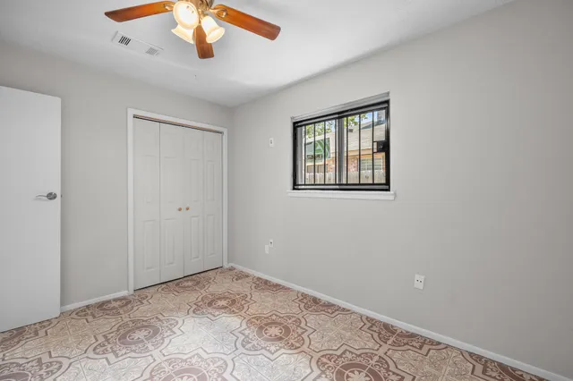 a view of empty room with wooden floor and fan