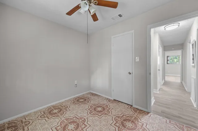an empty room with a window and a fan