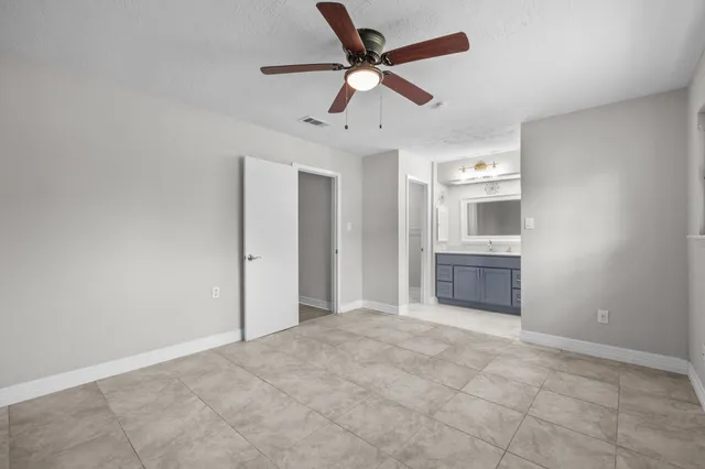 a view of a livingroom with a ceiling fan & windows