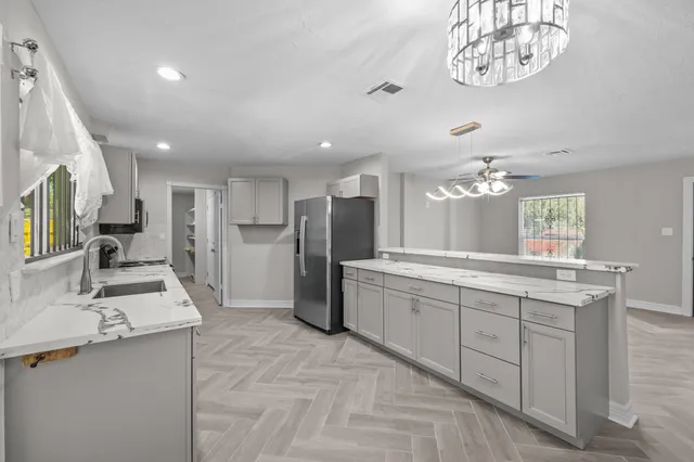 a large kitchen with a large counter top appliances and cabinets