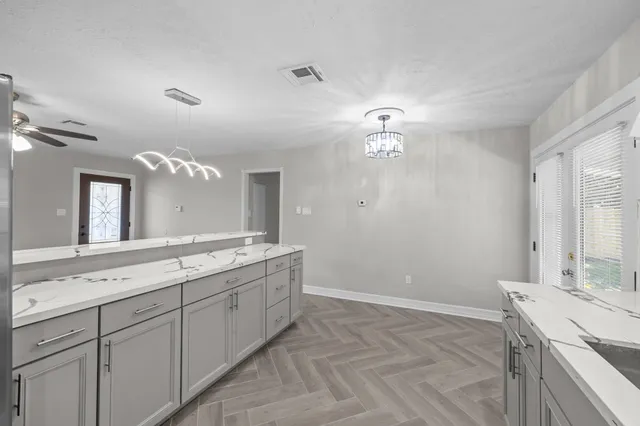 a spacious bathroom with a granite countertop sink a mirror and a vanity