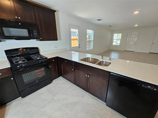 a kitchen with a sink stove and microwave