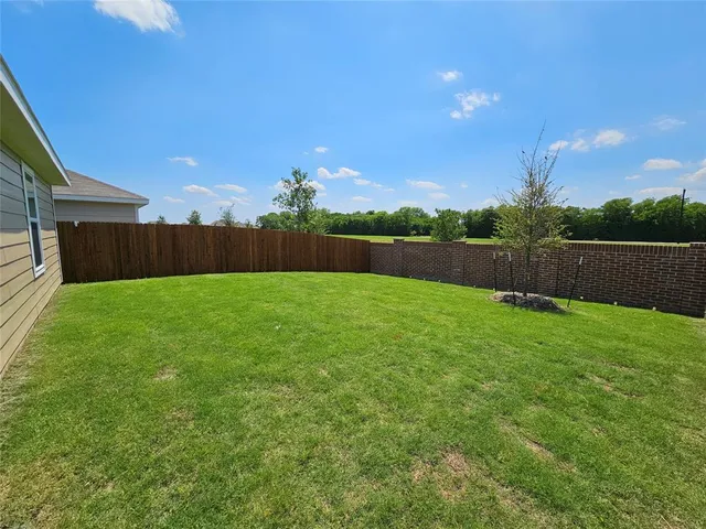 a view of yard with swimming pool and green space