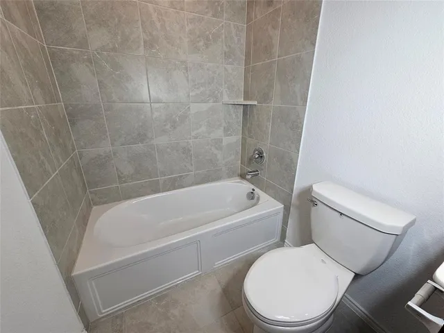 a white toilet and tub sitting next to a bathroom sink