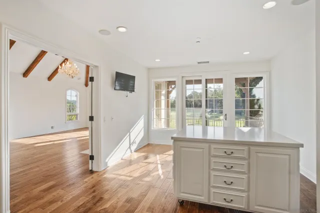 a hallway with a large window and wooden floor