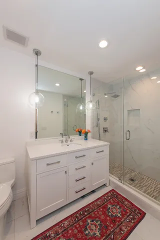 a bathroom with a double vanity sink toilet and shower