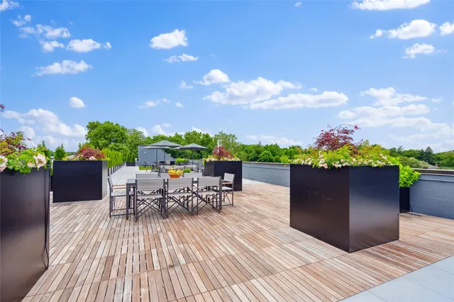 a view of a patio with a table and chairs under an umbrella with potted plants