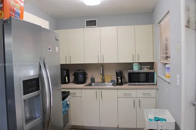 a kitchen with stainless steel appliances white cabinets and a refrigerator