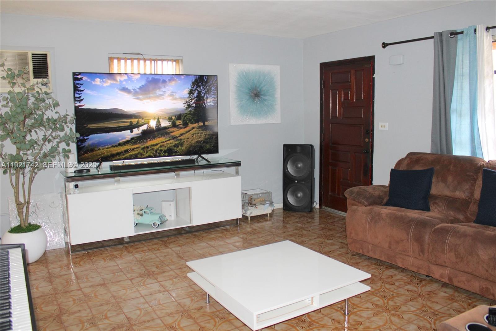4940 Southwest 114th Avenue Miami, FL 33165 - Photo 7 of 31 a living room with furniture and a flat screen tv