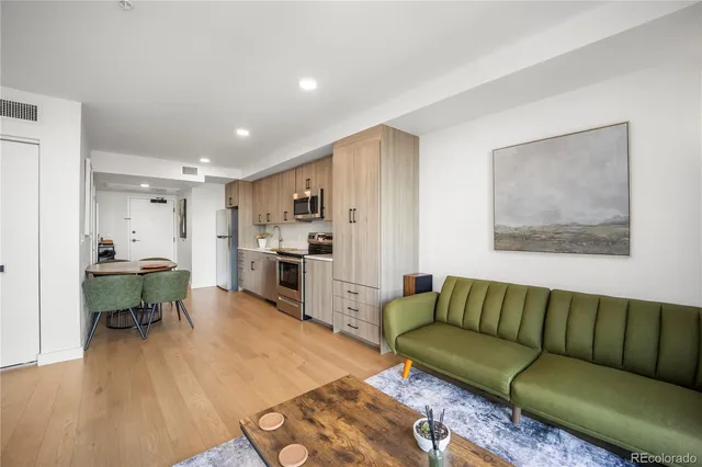 a living room with furniture and a dining table with kitchen view