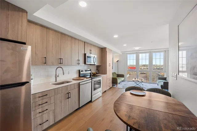a kitchen with sink refrigerator dining table and chairs