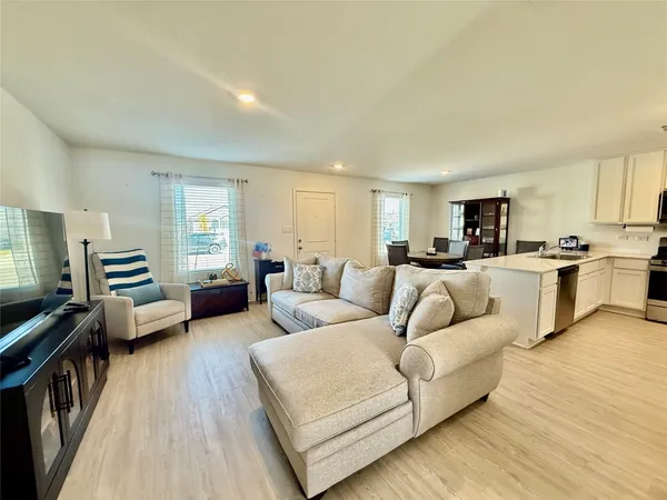 a living room with furniture and a wooden floor