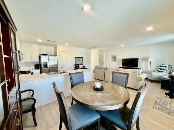 a view of a dining room with furniture and a kitchen