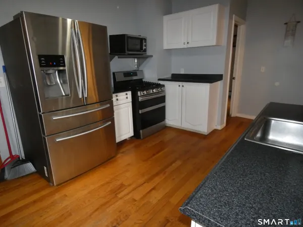 a kitchen with granite countertop a refrigerator and a sink
