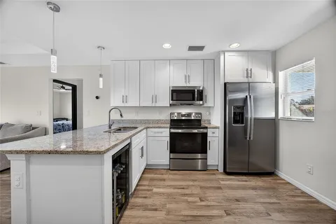 a kitchen with stainless steel appliances granite countertop a refrigerator a stove a sink and a microwave