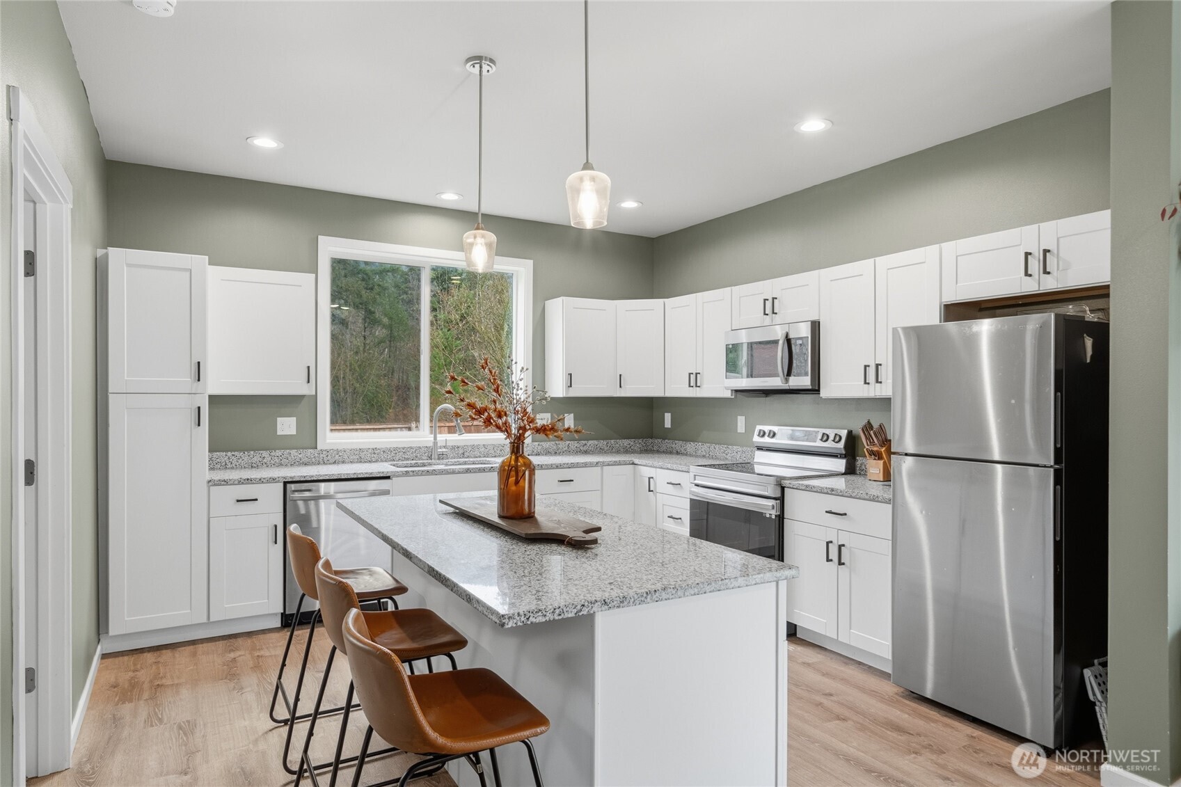 8470 Golden Valley Drive Maple Falls, WA 98266 - Photo 6 of 30 a kitchen with a refrigerator a stove a sink dishwasher and white cabinets with wooden floor