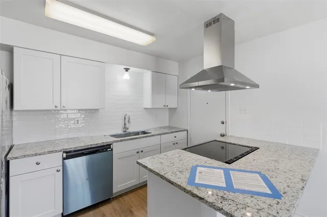 a kitchen with stainless steel appliances granite countertop a sink a stove and white cabinets