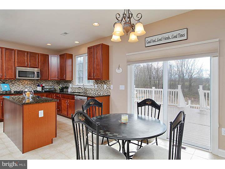 830 Derius Drive Mickleton, NJ 08056 - Photo 11 of 24 a kitchen with stainless steel appliances granite countertop a stove a refrigerator a kitchen island a dining table and chairs