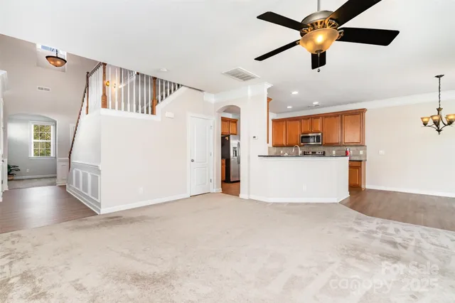 a view of a kitchen with a stove cabinets a ceiling fan and wooden floor