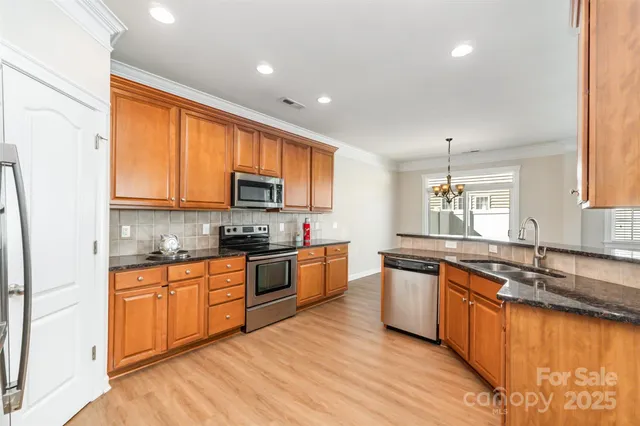 a large kitchen with stainless steel appliances granite countertop a stove sink and cabinets