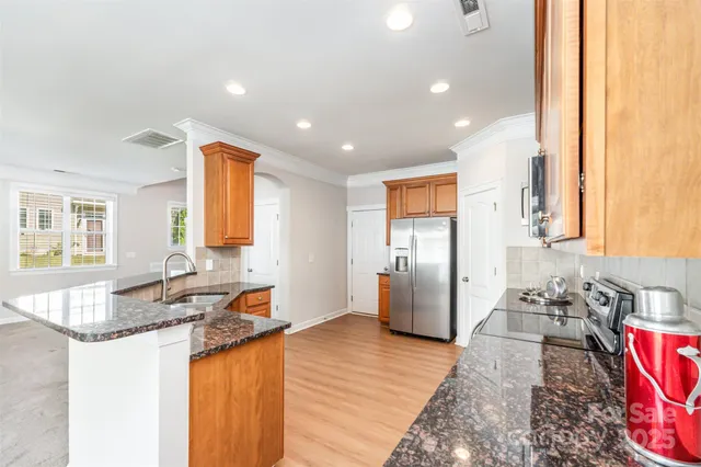 a kitchen with stainless steel appliances granite countertop a sink stove and refrigerator