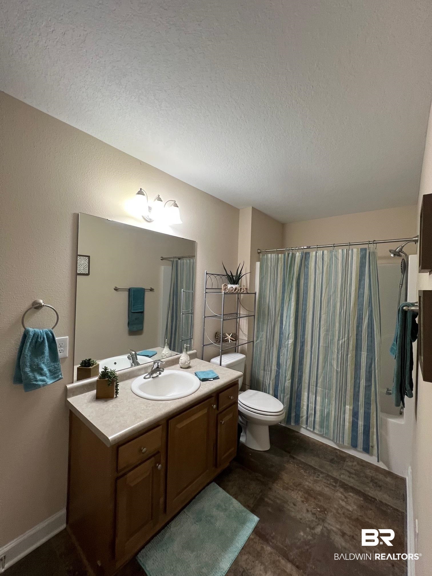 10257 Lyttleton Loop Lillian, AL 36549 - Photo 19 of 31 Full bathroom featuring vanity, shower / tub combo, and a textured ceiling