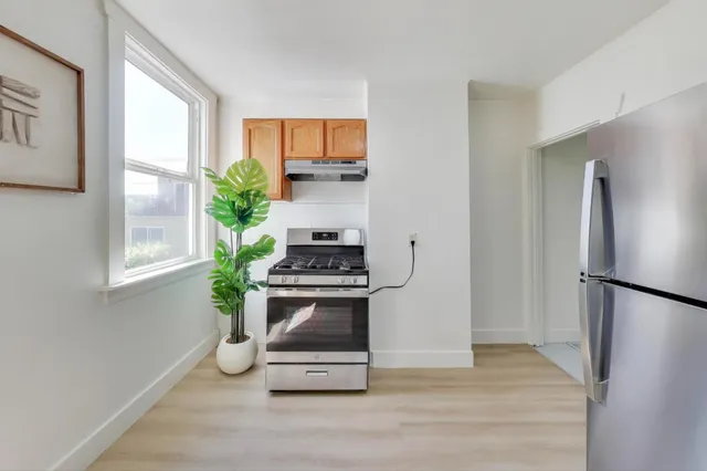 a kitchen with stainless steel appliances a stove a refrigerator and a window