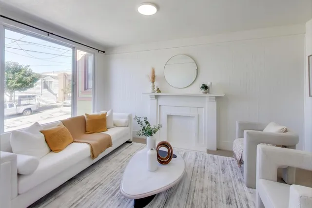 a living room with furniture a fireplace and a large window