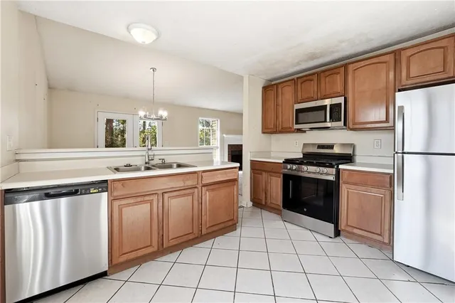 a kitchen with stainless steel appliances granite countertop a refrigerator and a stove top oven