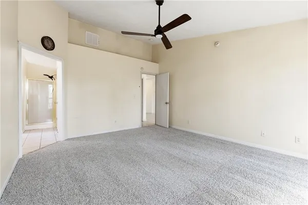 a view of a room with a ceiling fan and a window