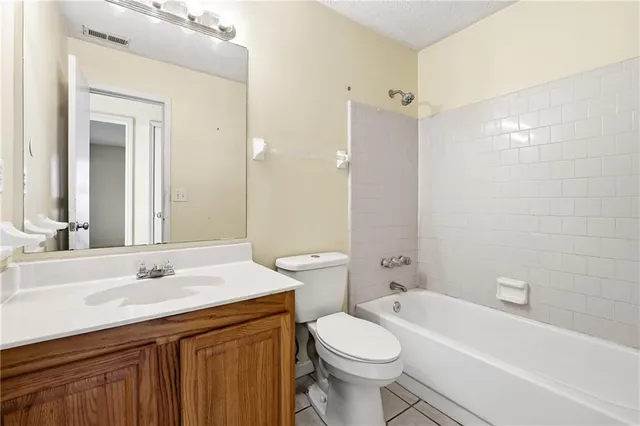 a bathroom with a sink a toilet and a large mirror