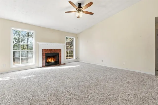 a view of empty room with a fireplace and fan