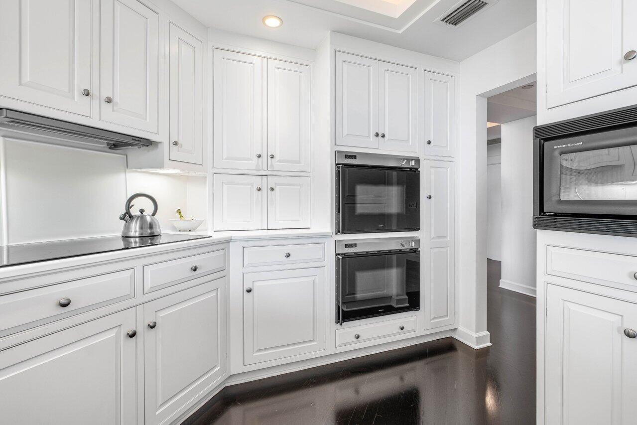 3001 Southeast Island Point Lane, Unit 12 Stuart, FL 34996 - Photo 14 of 44 a kitchen with white cabinets and stainless steel appliances