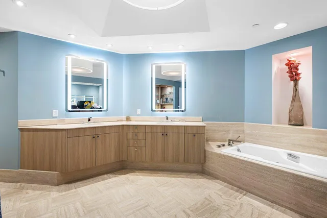 a spacious bathroom with a tub sink and mirror
