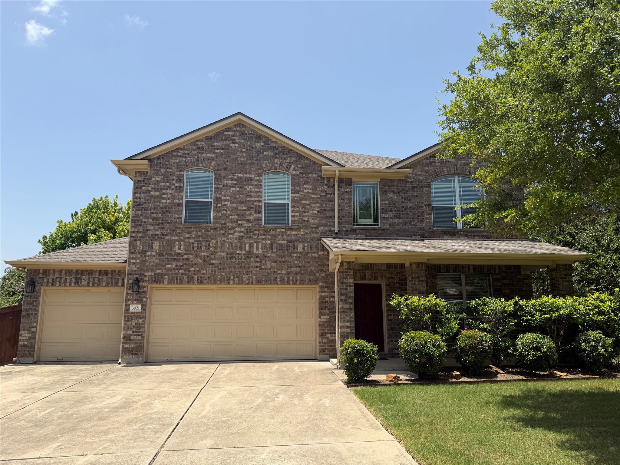 3021 Grand Mission Way Pflugerville, TX 78660 - Photo 1 of 31 An inviting brick facade with a prominent two-car garage offers classic curb appeal.