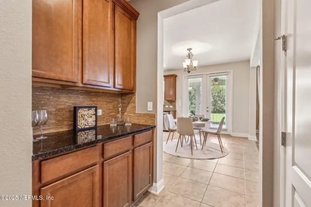 a kitchen with a dining table chairs sink and cabinets