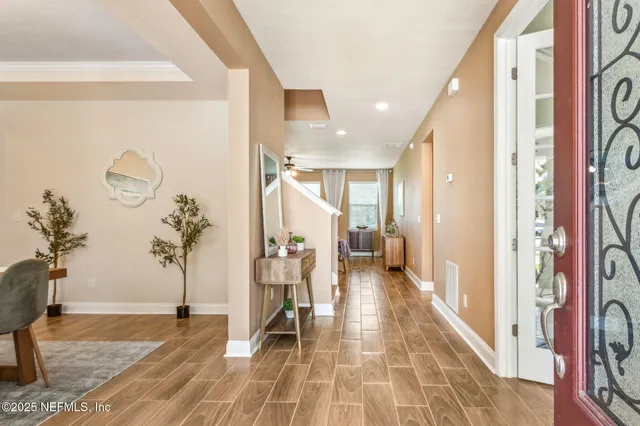 a living room with furniture a large window and a dining table