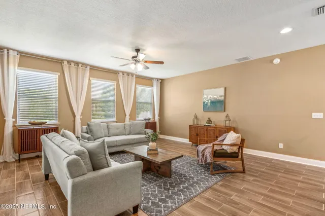a living room with furniture and a ceiling fan