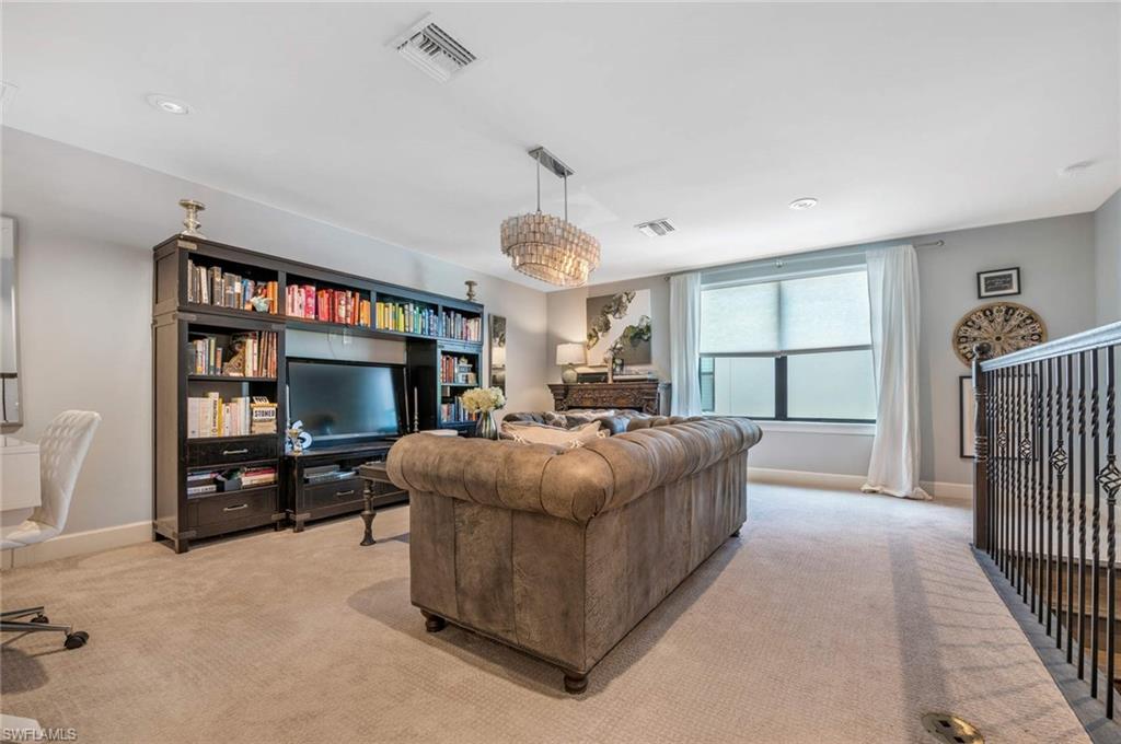 16359 Halberry Lane Naples, FL 34110 - Photo 14 of 30 a living room with furniture a flat screen tv and a fireplace
