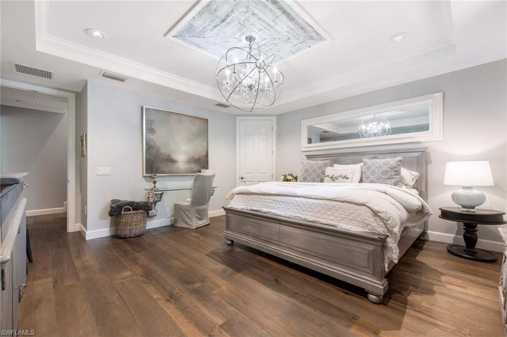 16359 Halberry Lane Naples, FL 34110 - Photo 17 of 30 a bedroom with a bed and a chandelier