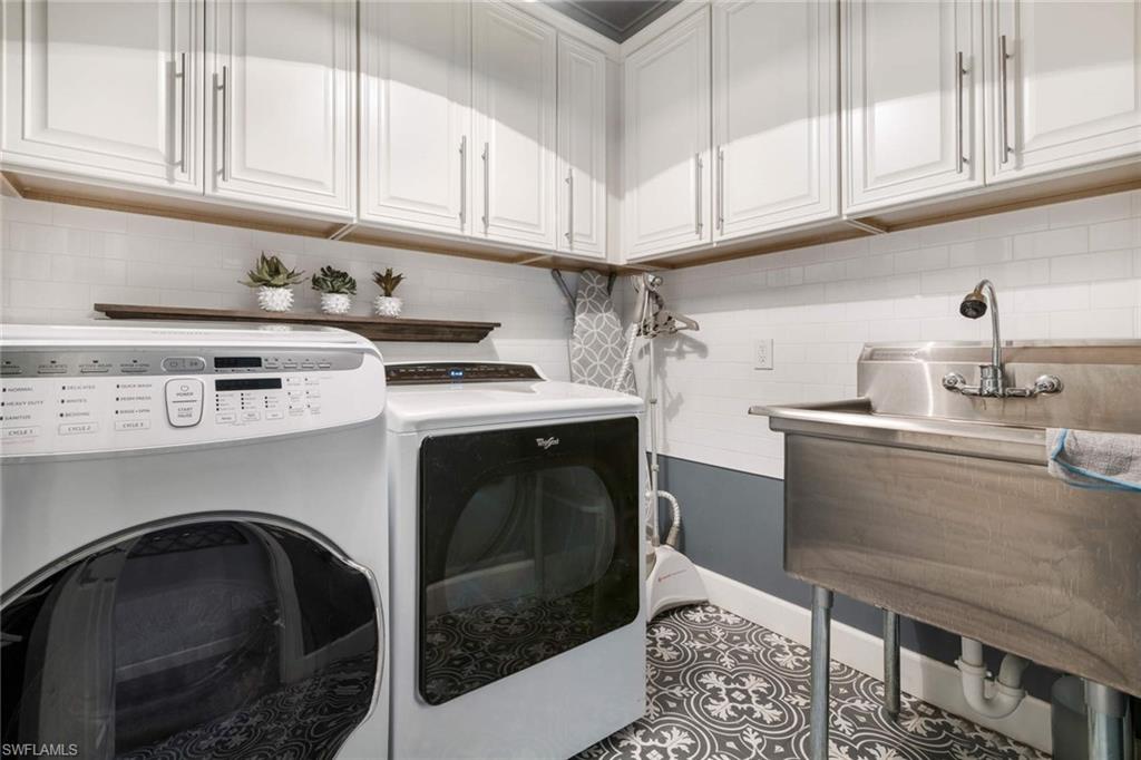 16359 Halberry Lane Naples, FL 34110 - Photo 24 of 30 a kitchen with stainless steel appliances granite countertop a stove a microwave and white cabinets